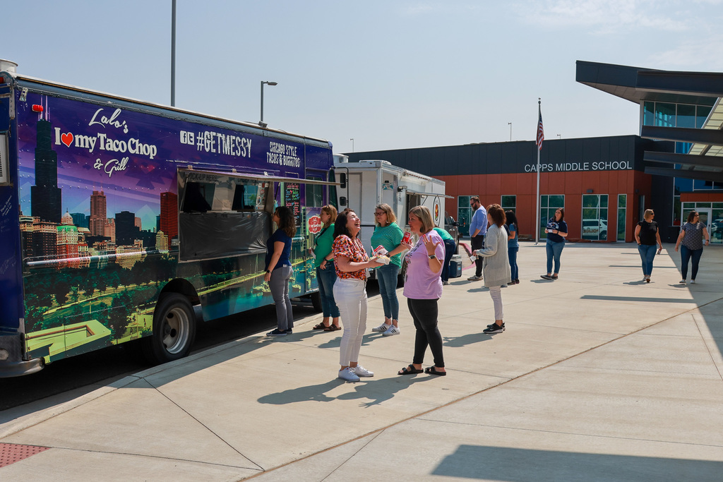 principals in line at food truck laughing