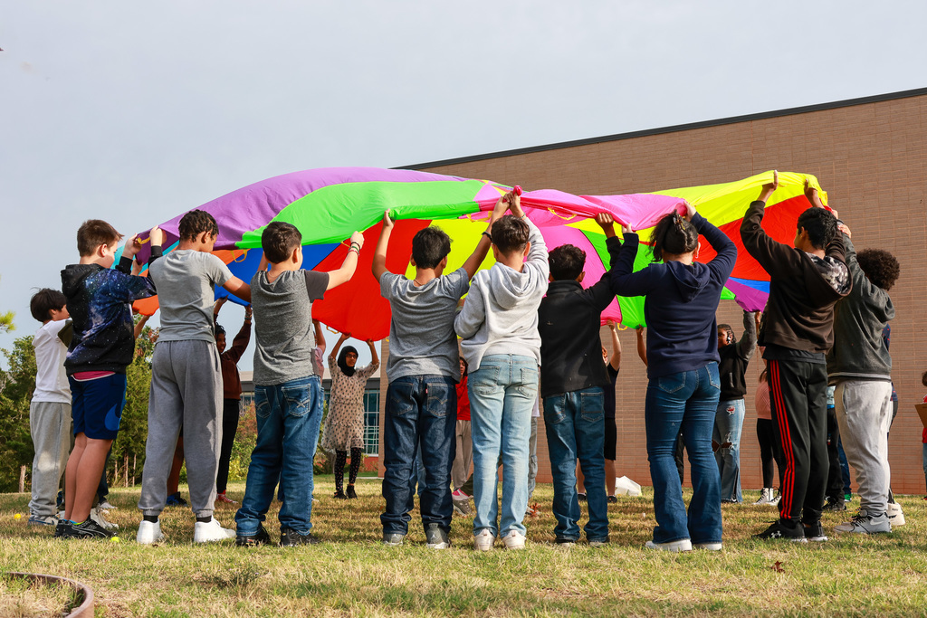 students lifting up parachute